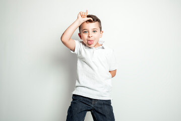 five year old boy posing over white studio background