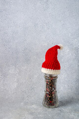 a glass jar with pepper seeds in a Santa Claus hat, a copy of space
