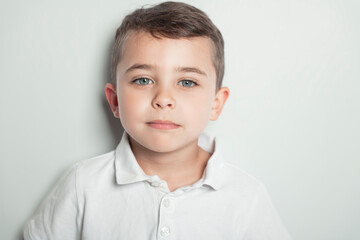 five year old boy posing over white studio background