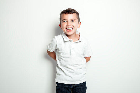 five year old boy posing over white studio background