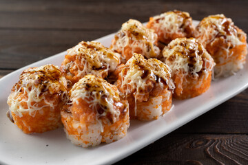 Japanese Baked sushi rolls. Tasty and artistic food for restaurant or cafe menu. Rolls on the dish. Art of cuisine. Sushi menu