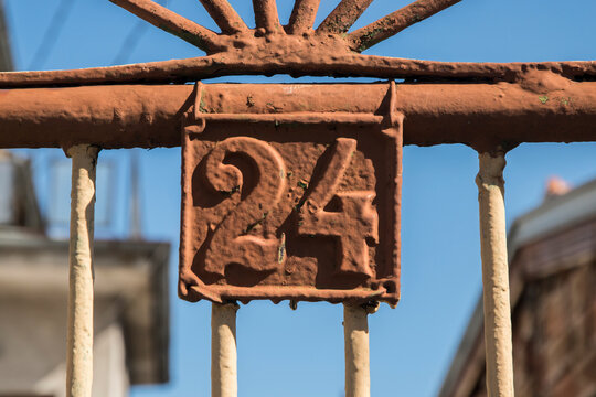 Old retro weathered cast iron plate with number 24 closeup