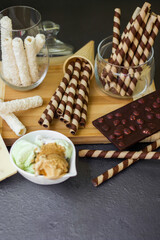 Sweet table with chocolate waffles, chocolate and ice cream on a black background