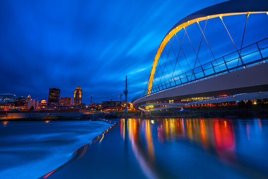 Des Moines River walk bridge reflected in the Des Moines River during blue hour. Des Moines, Iowa. 