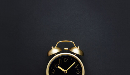 Golden vintage alarm clock on a black background. Black Friday time. Selective focus, copy space