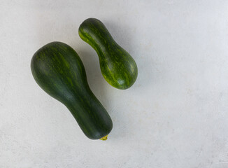 Raw zucchini on a light gray table. Top view, copy space