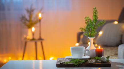 cup of coffee with burning candles and christmas decorations at home