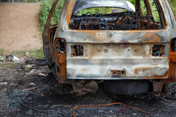 Car after a fire. Burnt rusty car after fire or accident. Car after the fire, crime of vandalism, riots. Arson car. Accident on the road due to speeding. Explosion.