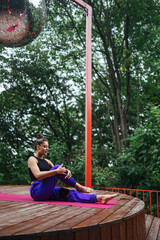 A young woman in doing yoga in the yard