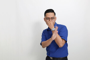 Young asian man standing while showing bad smell gesture. Isolated on white background