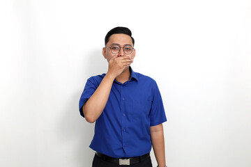 Young asian man standing while laughing and covering his mouth. Isolated on white background