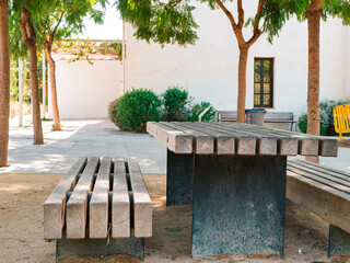 A bench and a table made of wooden boards and standing in the courtyard. Nice place to rest and eat