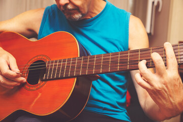 Adult male practicing Spanish guitar at home