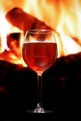 A glass of red wine on the background of the fireplace