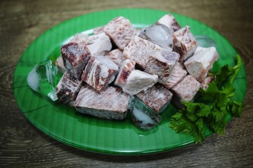 Pile of raw meats on green plate