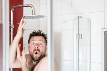 Man in the shower, in which the water stopped flowing due to a breaking or due to an energy crisis.