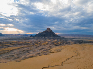 Factory butte with dramatic clouds and sun