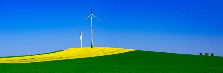 Panorama Rapeseed Field With Wind farm - Renewable Energy. Alternative and green energy source. Germany.