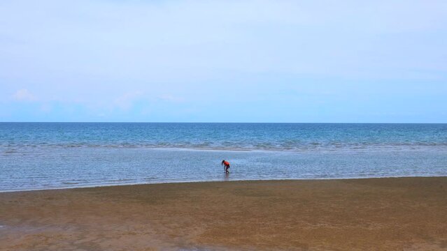 Une fille joue seule sur une plage de Cha Am en Tha&iuml;lande