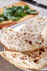 Delicious gourmet flat bread kutabs with herbs and cheese on a plate.