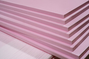 Pink Extruded Polystyrene XPS foam thermal insulation boards stacked in the construction site. High...