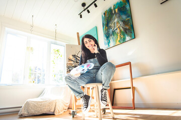 Obraz premium Portrait of a woman artist working on several art projects on her studio