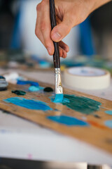 Obraz premium Artist mixes paints with a brush on a palette