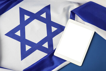 Tablet computer and flag of Israel on color background