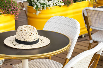 Stylish hat on table in outdoor cafe
