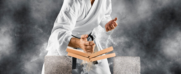 Karate master breaks a wooden board with his hand