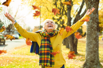 Happy elderly senior woman in an autumn park.