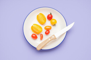 Plate with fresh tomatoes on color background