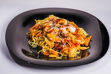 A bowl of delicious spicy asian shrimp noodle soup with mushroom, red pepper, snow peas and scallions.