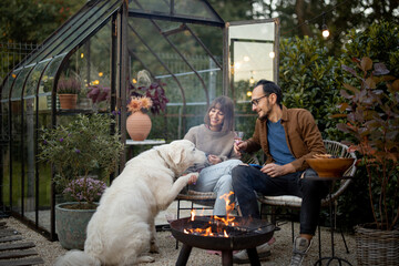 Young lovely couple having fun spending evening time with a dog during romantic and atmospheric...
