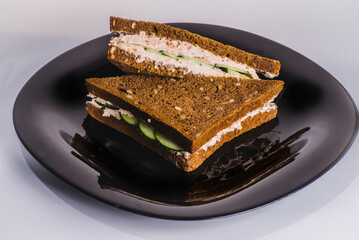 homemade baguette with smoked salmon, onions and arugula. Dark background.