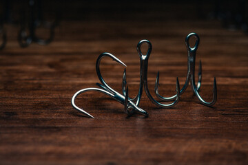 Fishing hooks on a wooden board. Close-up of a fishing hook