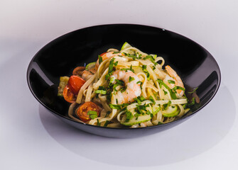 Tagliatelle pasta with fried shrimps, cheese Parmesan, parsley and zucchini ribbons, handmade dish