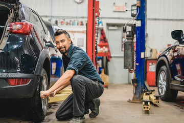 Nice and cool mechanic changing car tire at work