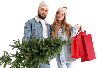 Young couple with Christmas tree and shopping bags on white background