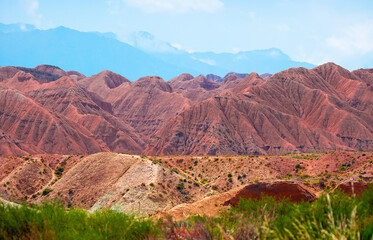 Natural unusual landscape of red rocks against the backdrop of blue mountains. The extraordinary beauty of nature is similar to the Martian landscape. Amazingly beautiful landscape.