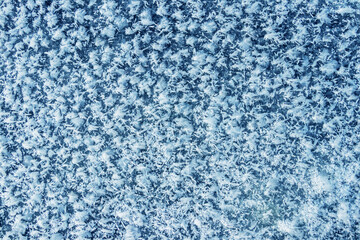 Big fluffy snowflakes on the surface of the ice. Winter and Christmas background