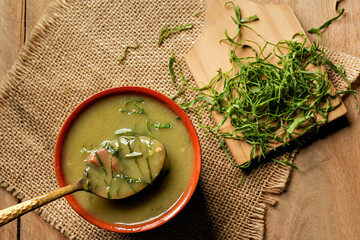 green broth with pepperoni and cabbage with top view on rustic wooden table