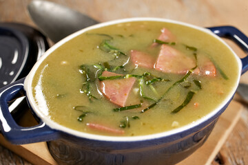green broth with pepperoni and cabbage with top view on rustic wooden table