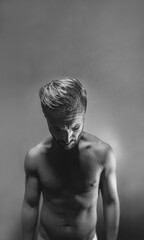 Fototapeta premium Dark creative artistic portrait of a mature naked man in black and white with copyspace. Mental health, psychology disorder, sadness or depression concept.