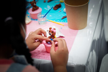 girl making dolls made from sugar and bread flour are used to decorate at parties. cake dolls are made by Handmade. Selective focus.	                           