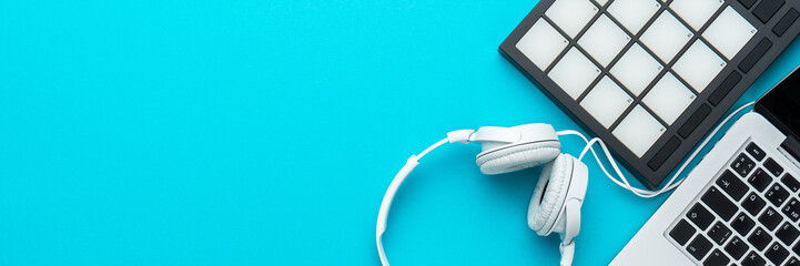 Minimalist photo of bedroom producer setup over turquoise blue background. Top view of home studio...