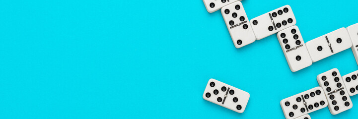 Domino pieces on turquoise blue background with copy space. Flat lay minimalist photo of some...