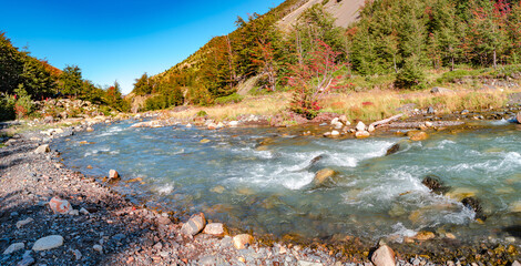 Panoramic view over a fast mountain river in Torres del Paine National Park at sunny day and blue...