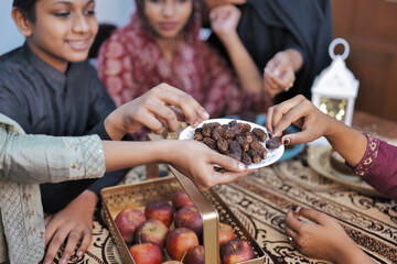 Happy Indian Muslim family celebrating Eid Mubarak and Having Eid Feast at Home