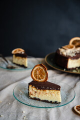 Piece of Ukrainian cheesecake syrnyk with chocolate and almond glaze on vintage glass plate.